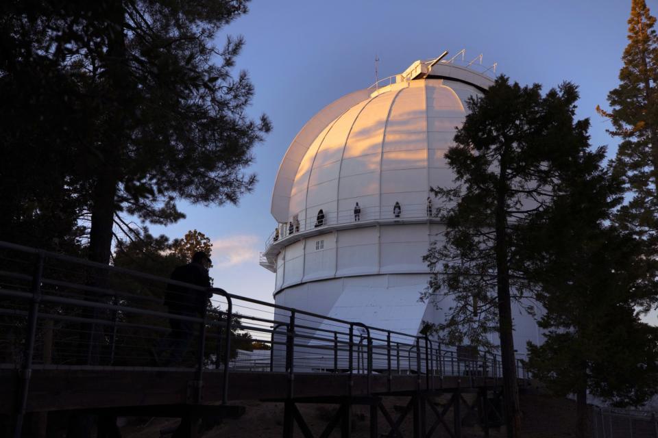 Models standing on a catwalk at the Mt. Wilson Observatory.