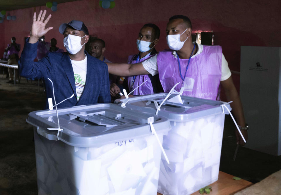 Ethiopia's Prime Minister Abiy Ahmed, left, waves to his supporters after casting his vote in the general election in his home town of Beshasha, in the Oromia region of Ethiopia Monday, June 21, 2021. Ethiopia began voting in the greatest electoral test yet for Prime Minister Abiy Ahmed as war and logistical issues mean ballots won’t be cast in more than 100 of the 547 constituenciesacross the country. The election is the centerpiece of a reform drive by Abiy, whose rise to power in 2018 seemed to signal a break with decades of authoritarian rule and led to him winning a Nobel Peace Prize. (AP Photo/Mulugeta Ayene)