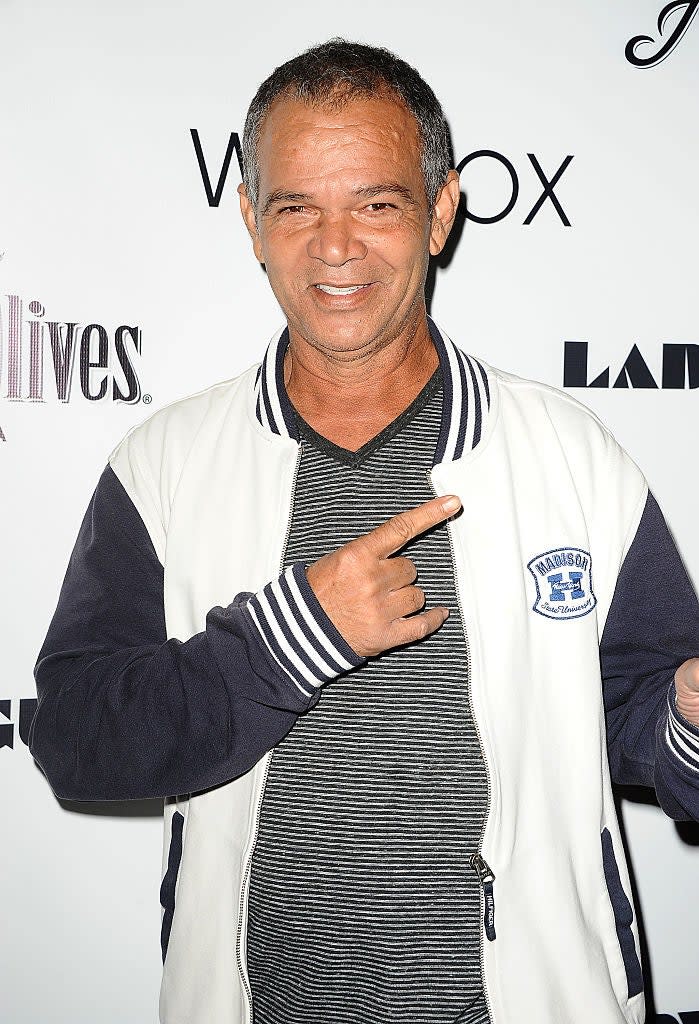 Roberty Fenty in a varsity jacket and striped shirt pointing at himself, smiling at a press event
