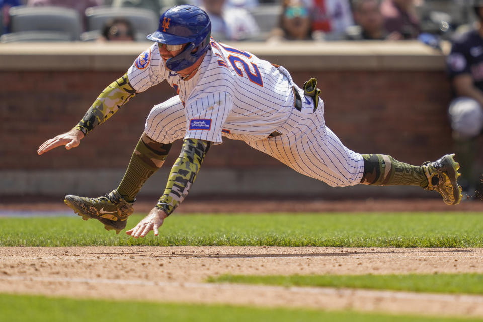 New York Mets' Pete Alonso dives home to score on an RBI sacrifice fly hit by Gary Sanchez off Cleveland Guardians starting pitcher Tanner Bibee (61) in the sixth inning of the opener of a split doubleheader baseball game, Sunday, May 21, 2023, in New York. (AP Photo/John Minchillo)