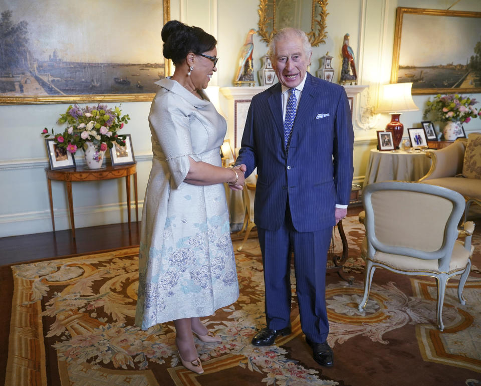 El rey Carlos III de Gran Bretaña, derecha, le da la mano al a Secretaria General de la Mancomunidad, la baronesa Scotland de Asthal, durante una audiencia en el Palcio de Buckingham en Londres el miércoles 13 de marzo de 2024. (Yui Mok/Pool Photo vía AP)