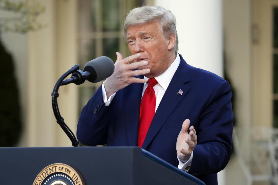 President Donald Trump holds his hand to his face as he talks about masks during a briefing about the coronavirus in the Rose Garden of the White House, Monday, March 30, 2020, in Washington. (AP Photo/Alex Brandon)