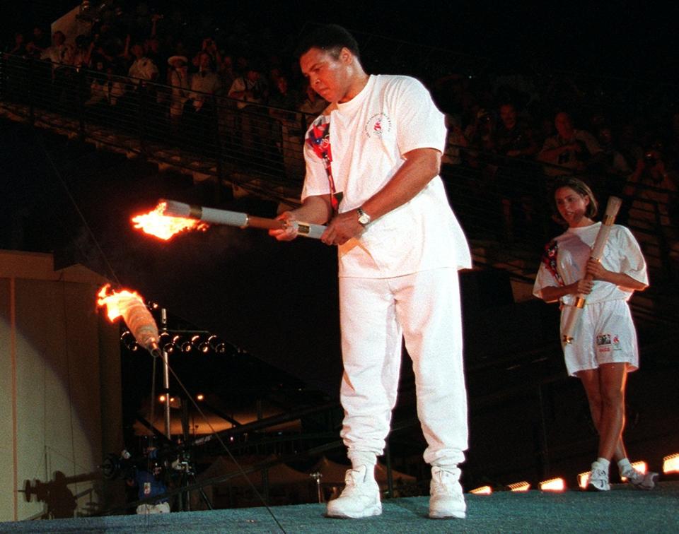 Boxing legend Muhammed Ali lights the Olympic flame, as American swimmer Janet Evans looks on during the 1996 Summer Olympic Games opening ceremony in Atlanta, July 19, 1996. (AP Photo/Michael Probst)