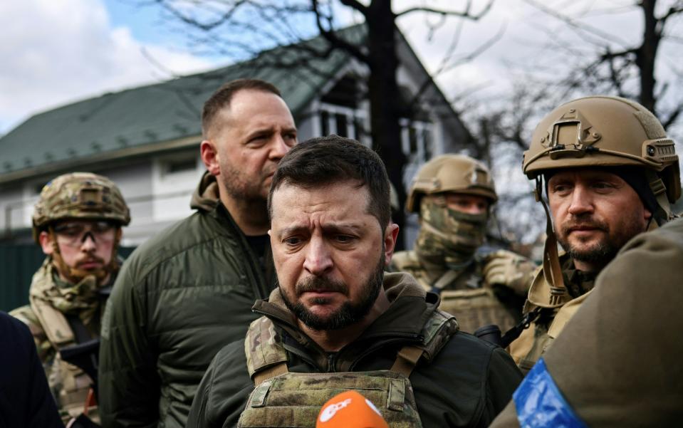 Ukainian President Volodymyr Zelensky (C) speaks to the press in the town of Bucha, northwest of the Ukrainian capital Kyiv, on April 4, 2022.