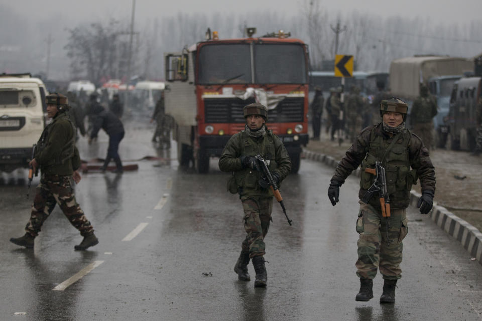 Indian paramilitary soldiers patrol near the site of an explosion in Pampore, Indian-controlled Kashmir, Thursday, Feb. 14, 2019. Security officials say at least 10 soldiers have been killed and 20 others wounded by a large explosion that struck a paramilitary convoy on a key highway on the outskirts of the disputed region's main city of Srinagar. (AP Photo/Dar Yasin)