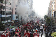 Firefighters attempt to put out fire at a market building during a fire at China town Thursday, Feb. 20, 2020, in Yangon, Myanmar. Firefighters contained a blaze in the 12-story building in the country's biggest city. (AP Photo/Thein Zaw)