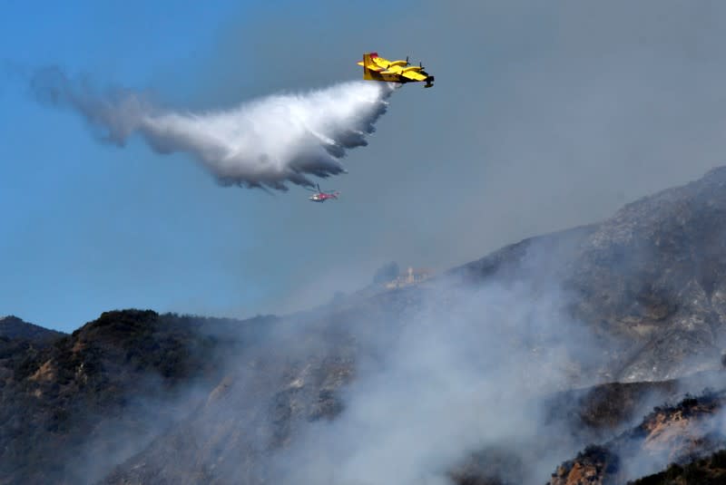 Firefighters battle a blaze from the air that was threatening homes in the Pacific Palisades community of Los Angeles, California, U.S.