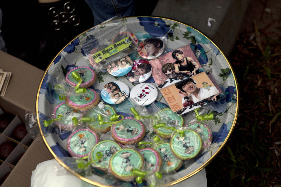 In this May 18, 2013 photo, members of a K-pop fan club for South Korean singer Kim Hyun Joong, sell souvenirs at a gathering of her fans at Ramon Castilla park in Lima, Peru. Joong was met by thousands of fans when he arrived at the airport in Peru's capital in February this year. (AP Photo/Martin Mejia)