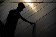 An employee checks solar panels near a hydrogen plant at Oil India Limited in Jorhat, India, Thursday, Aug. 17, 2023. Green hydrogen is being touted around the world as a clean energy solution to take the carbon out of high-emitting sectors like transport and industrial manufacturing. But it's not green hydrogen unless the energy used to produce it is renewable, like solar or wind energy. (AP Photo/Anupam Nath)