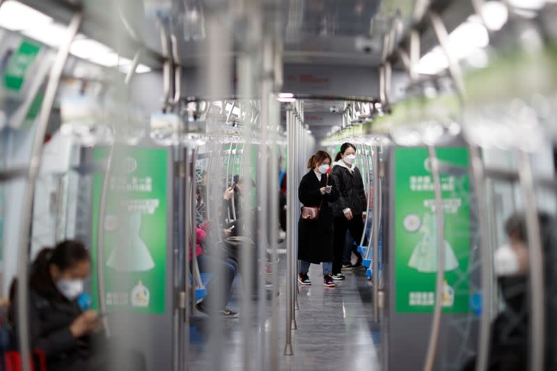 Personas ataviadas con máscaras faciales en un tren subterráneo en Pekín