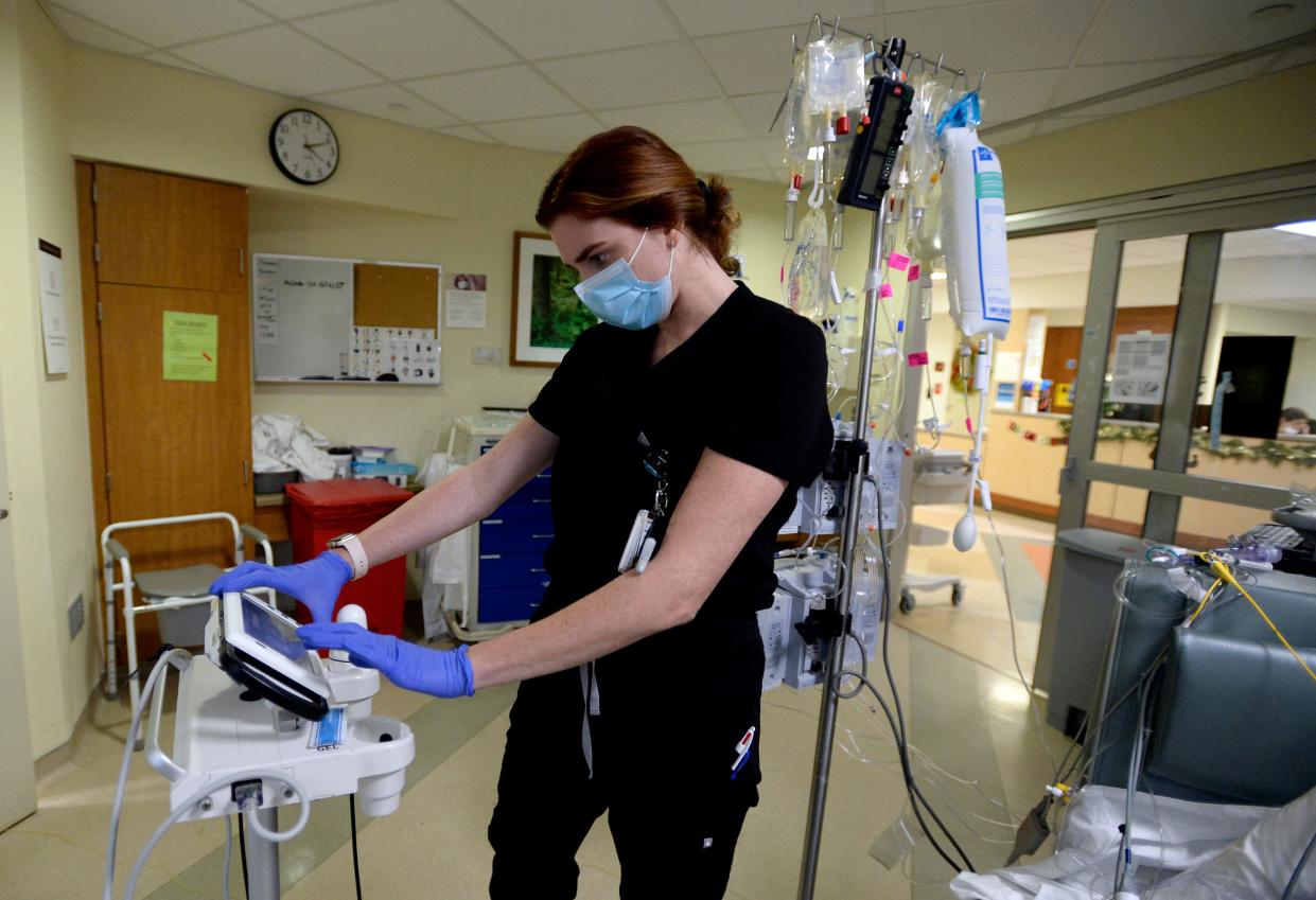 Registered nurse Lizzie Drummond takes care of a patient in the cardiovascular ICU unit at Vanderbilt University Medical Center on Thursday, Dec. 15, 2022, in Nashville, Tenn. This season has been a challenging one as a triple-demic of flu, COVID and RSV spread throughout the south.