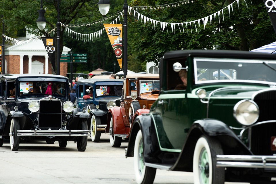 Historic vehicle owners take to their cars and line the streets of Greenfield Village in the Pass-in-Review parade at Old Car Festival.