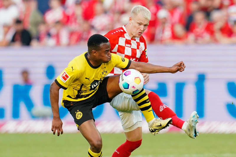 Dortmund's Youssoufa Moukoko (L) and Mainz's Andreas Hanche-Olsen battle for the ball during the German Bundesliga soccer match between FSV Mainz 05 anbd Borussia Dortmund at the Mewa Arena. Uwe Anspach/dpa
