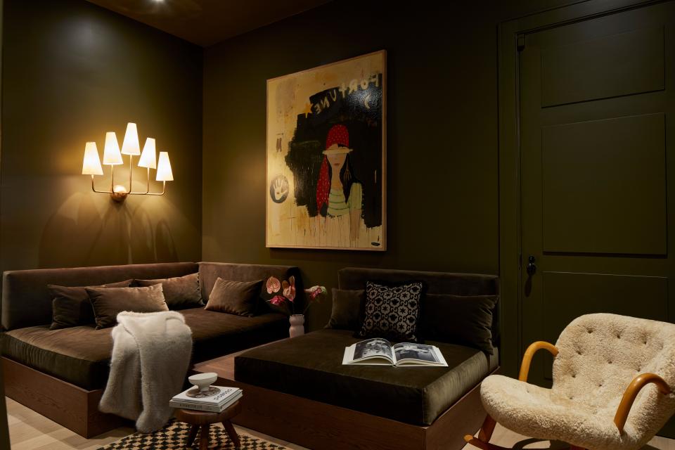 Covered in Farrow & Ball’s Studio Green from baseboard to ceiling created an intimate interior complete with cozy built-in chaises designed by Tali Roth, artwork by Justin Lyons, and Ponce Berga vintage Philip Arctander rocking chair.