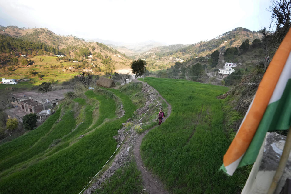 Village Defense Group member Usha Raina holding a gun walks in a filed at Kalal Khas Village, in Rajouri, India, Feb. 7, 2023. Days after seven Hindus were killed in the village in disputed Kashmir, Indian authorities revived a government-sponsored militia and began rearming and training villagers. The militia, officially called the “Village Defense Group,” was initially formed in the 1990s as the first line of defense against anti-India insurgents in remote villages that government forces could not reach quickly. (AP Photo/Channi Anand)