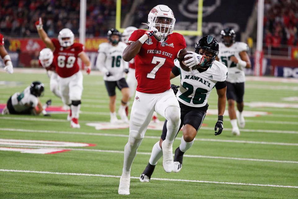 Fresno State running back Jordan Mims runs for a touchdown as Hawaii defensive back Leonard Lee trails during the first half of an NCAA college football game in Fresno, Calif., Saturday, Nov. 5, 2022. (AP Photo/Gary Kazanjian)