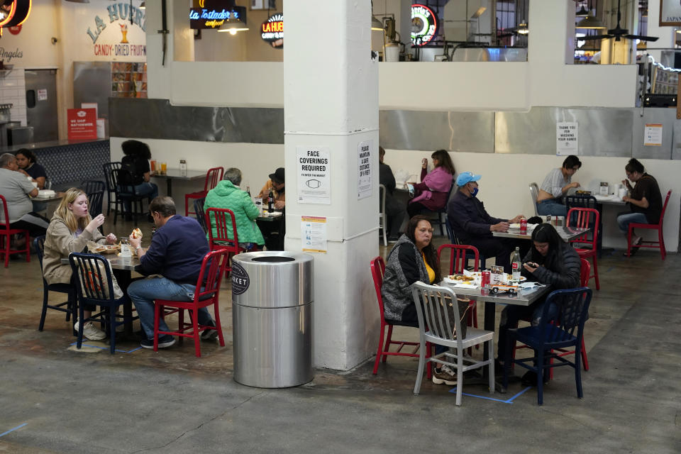 FILE - In this March 17, 2021 file photo Patrons eat lunch in an indoor space at Grand Central Market in Los Angeles. A rapid and sustained increase in COVID-19 cases in the nation's largest county requires restoring an indoor mask mandate even when people are vaccinated, Los Angeles County's public health officer said Thursday, July 15, 2021.(AP Photo/Marcio Jose Sanchez, File)