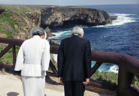 Japan's Emperor Akihito (R) and Empress Michiko bow in silent prayer at Banzai Cliff, or Puntan Sabaneta, to pay tribute to the Japanese soldiers and civilians who jumped off the rocky cliff 61 years ago rather than surrender to U.S forces in the bloody World War Two Battle of Saipan in Saipan June 28, 2005. REUTERS/Eriko Sugita/U.S. POOL/Files
