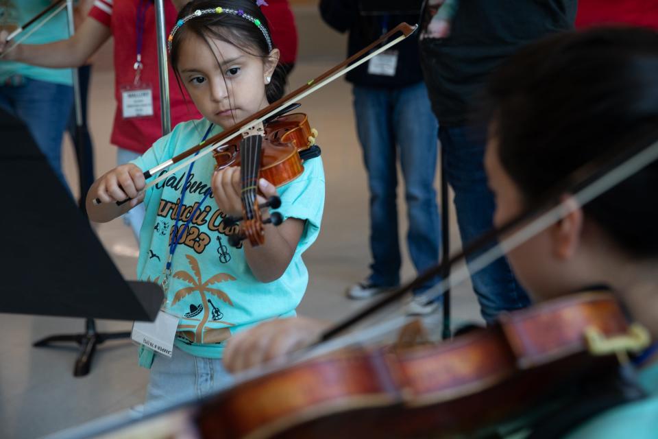 Violin instructor April Ibarra leads Ximena Banda, 7, during a mariachi camp's beginner rehearsal at Robstown High School, on Thursday, June 29, 2023, in Texas.