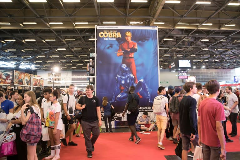 Visitors walk past a large poster for manga comic series 'Cobra the Space Pirate' by Buichi Terasawa at the 2018 Japan Expo exhibition on July 5, 2018 in Villepinte, near Paris