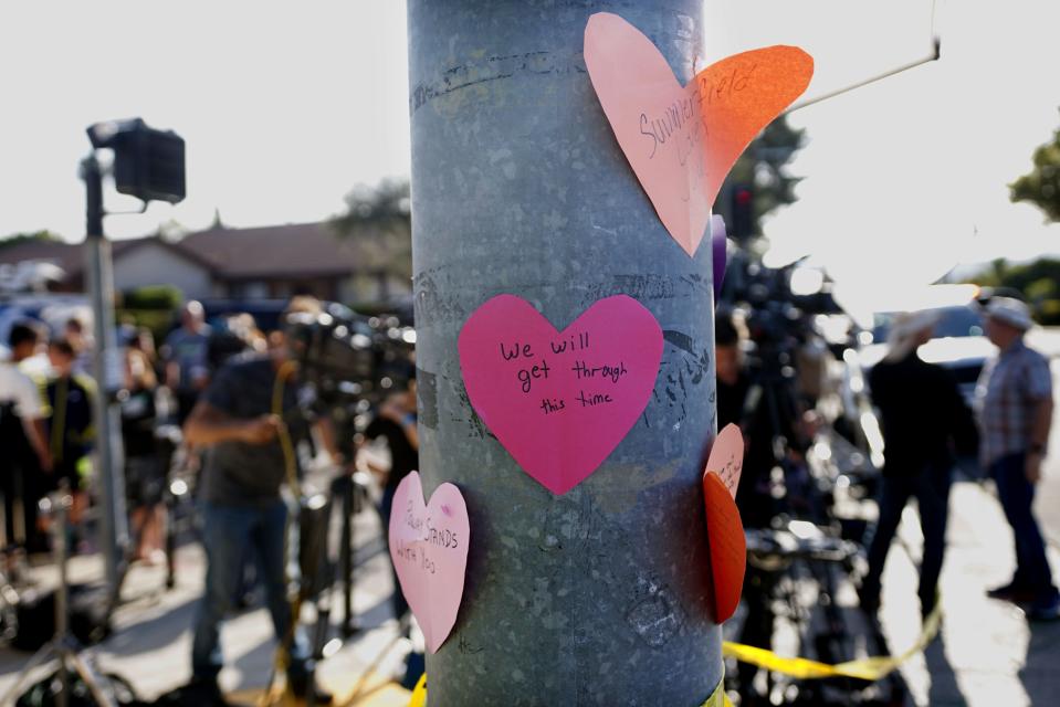 Hand-written notes are displayed on a light post across the street from the Chabad of Poway Synagogue after a shooting on April 27, 2019,