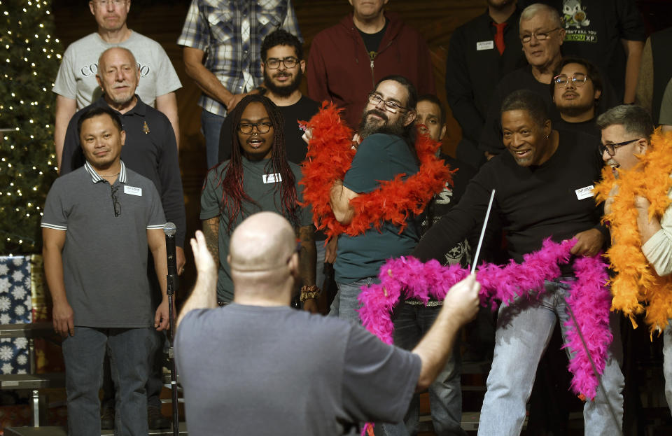 Joey Young, assistant artistic director of the Out Loud Colorado Springs Men's Chorus, leads part of the group during a rehearsal for its Christmas program in Colorado Springs, Colo., on Wednesday, Nov. 30, 2022. (AP Photo/Thomas Peipert)