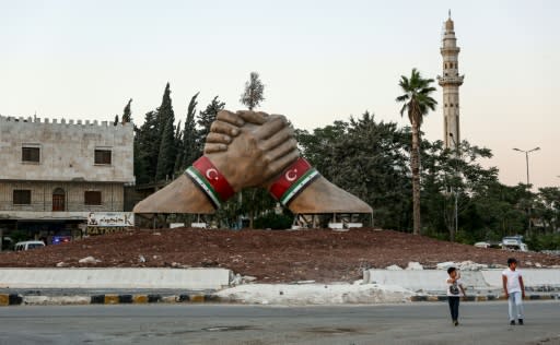 A sculpture of two hands with both the Syrian rebel and Turkish flags shows Ankara's influence in the Aleppo province of northern Syria