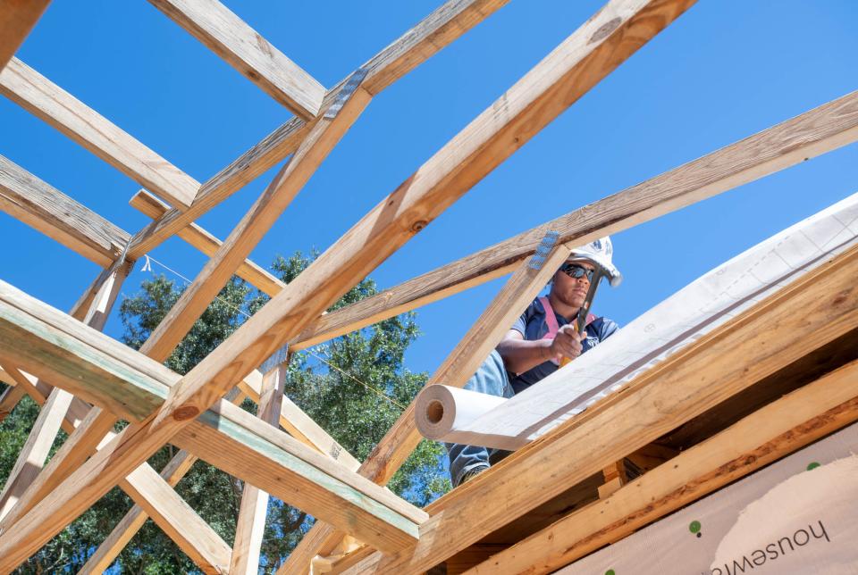 Marnetia Davis works on the roof while building a Habitat for Humanity house in Pensacola on Tuesday, Sept. 27, 2022.