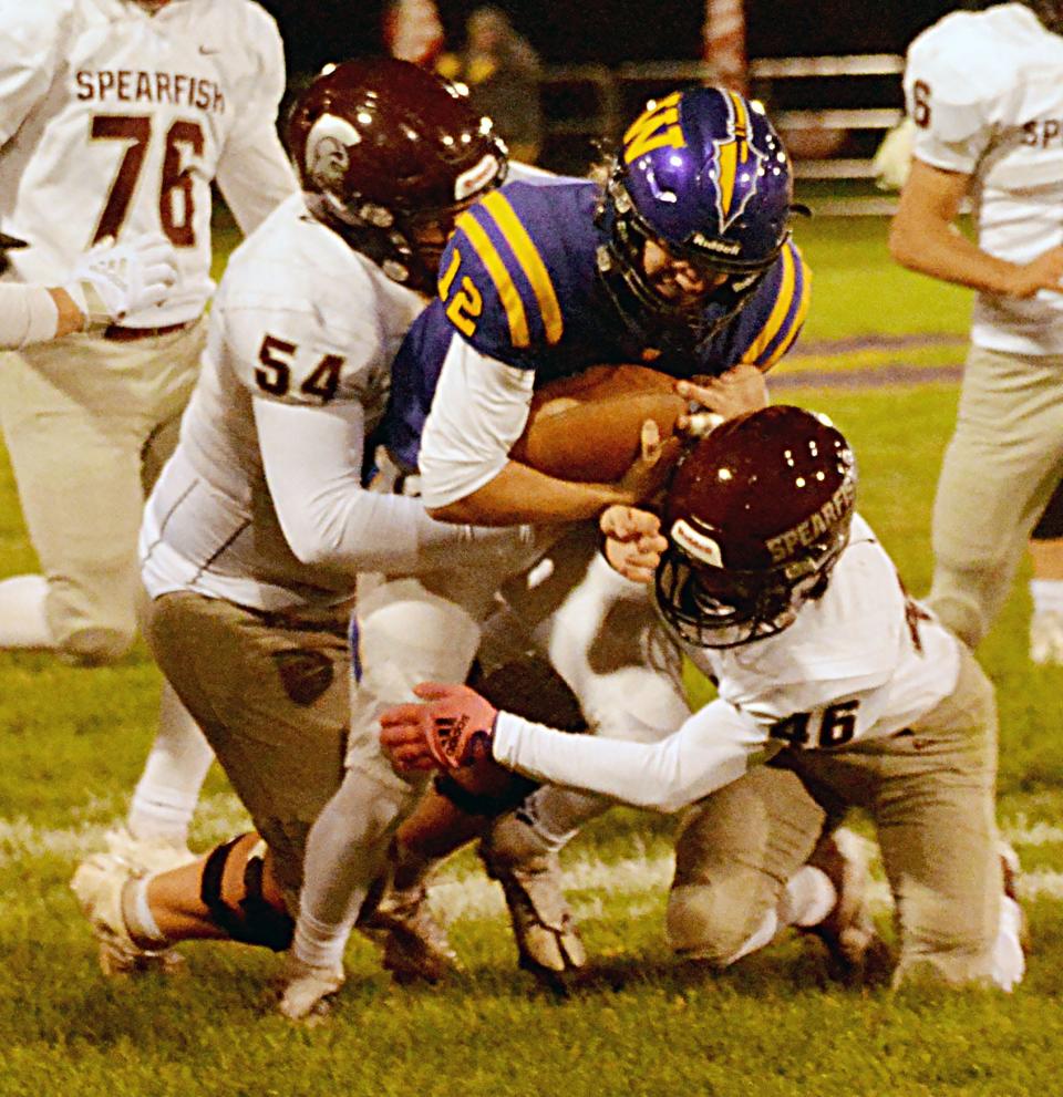 Watertown quarterback Treyton Himmerich is tackled by Spearfish defenders Dawson Wood (54) and Aiden Meverden during their Class 11AA high school football game on Friday, Oct. 14, 2022 at Watertown Stadium. The Arrows won 26-7.