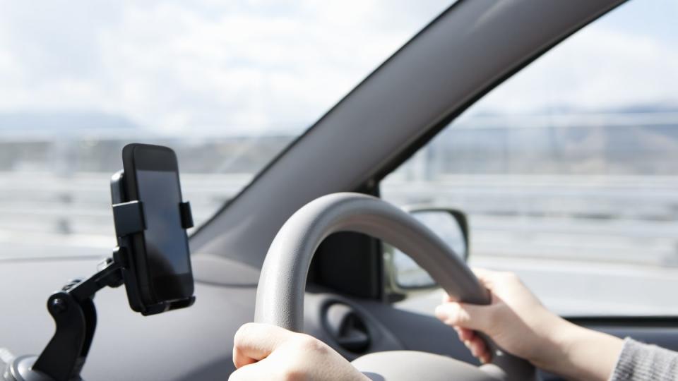 a woman driving a car with a phone mount