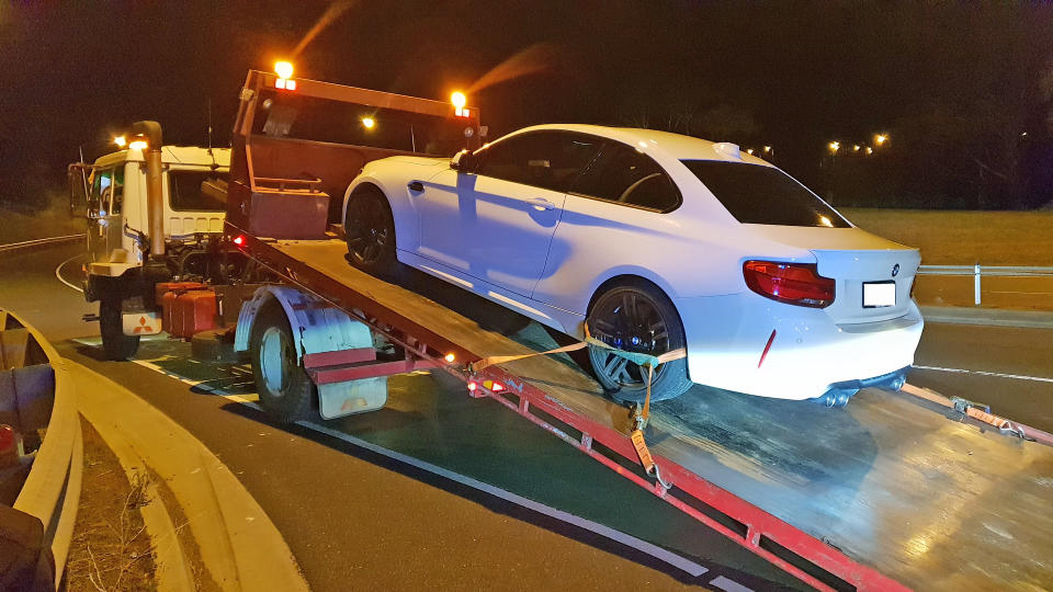 A white BMW M2 is confiscated by police at Bowen Bridge, Tasmania.