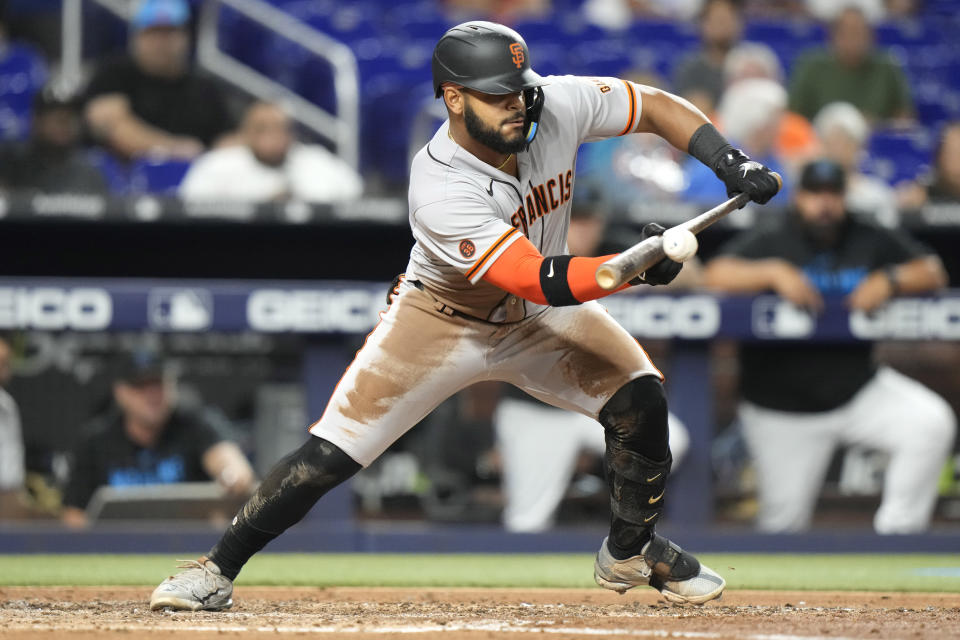 San Francisco Giants' Heliot Ramos bunts before reaching first on a throwing error by Miami Marlins starting pitcher Jesus Luzardo during the fourth inning of a baseball game, Monday, April 17, 2023, in Miami. (AP Photo/Lynne Sladky)