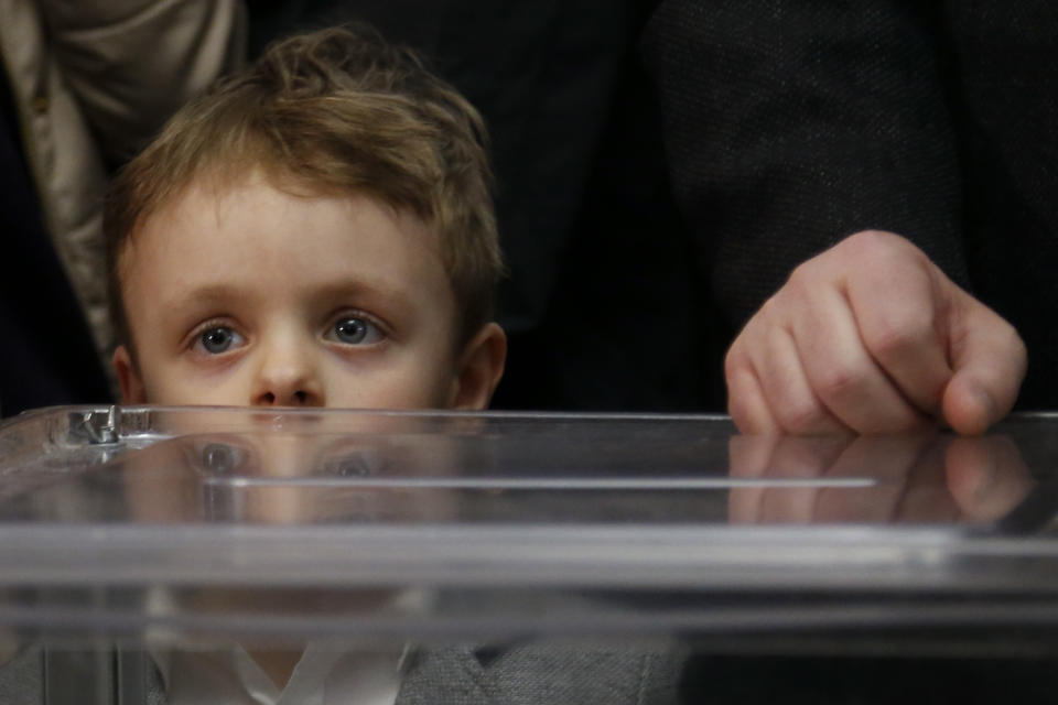 Ukrainian President Petro Poroshenko speaks to the media as his grandson Petro looks at them, at a polling station during the second round of presidential elections in Kiev, Ukraine, Sunday, April 21, 2019. Top issues in the election have been corruption, the economy and how to end the conflict with Russia-backed rebels in eastern Ukraine. (AP Photo/Efrem Lukatsky)