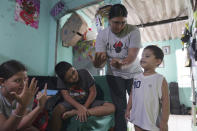 Cindy, second from right, along with her son and niece, help their young neighbor practice his numbers, on Friday, May 20, 2022, in San Salvador, El Salvador. In 2014 she was imprisoned for an obstetric emergency that she suffered in a shopping mall bathroom. Since being released in 2020, she has reflected on the time lost, time away from work, her son, and her studies. She dreams of one day traveling abroad with her son and starting over in a new place. (AP Photo/Jessie Wardarski)