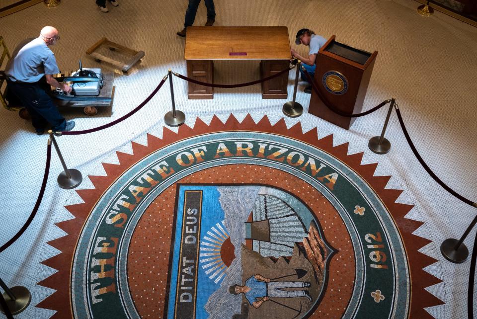 Workers disassemble the historic desk of George W. P. Hunt, Arizona's first governor, after Gov. Doug Ducey signed Senate Bill 1740 on July 6, 2022, during a ceremony in the old Arizona Capitol Rotunda. The bill was a $1 billion investment to secure Arizona's water future.