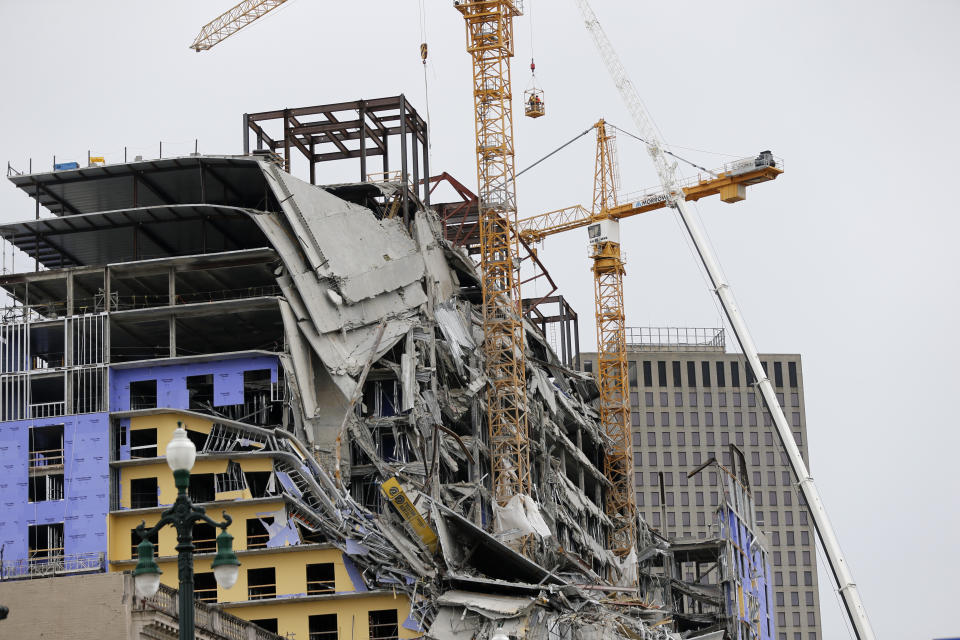 Workers in a bucket hoisted by a crane begin the process of preparing the two unstable cranes for implosion at the collapse site of the Hard Rock Hotel, which underwent a partial, major collapse while under construction last Sat., Oct., 12, in New Orleans, Friday, Oct. 18, 2019. Authorities plan to blow up the two towering construction cranes that have become unstable at the site of the collapsed hotel. They hope to bring down the cranes with series of small controlled blasts just ahead of approaching tropical weather. The mayor has imposed a state of emergency to seize property and force people out if necessary. They hope to avoid more damage to gas and power lines and historic buildings. (AP Photo/Gerald Herbert)