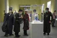 Visitors dressed in Chinese costumes tour the Hong Kong Palace Museum during the first day open to public in Hong Kong, Sunday, July 3, 2022. It showcases more than 900 Chinese artefacts, loaned from the long-established Palace Museum in Beijing, home to works of art representing thousands of years of Chinese history and culture. (AP Photo/Kin Cheung)