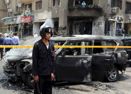 Policemen investigate the site of a car bomb attack on the convoy of Egyptian public prosecutor Hisham Barakat near his house at Heliopolis district in Cairo, Egypt, June 29, 2015. REUTERS/Mohamed Abd El Ghany