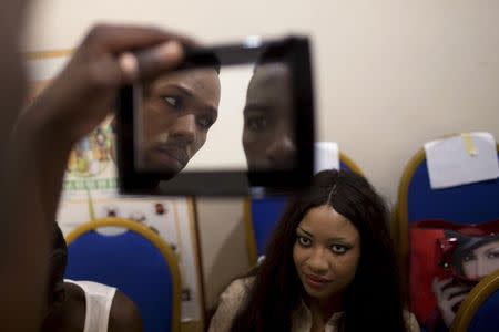 Models look at themselves in a mirror before the Festi'Bazin runway show in Bamako, Mali, October 16, 2015. REUTERS/Joe Penney