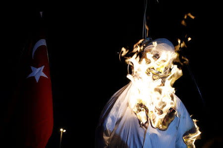 Supporters of Turkish President Tayyip Erdogan burn an effigy of U.S.-based cleric Fethullah Gulen hanged by a noose during a pro-government demonstration on Taksim Square in Istanbul, Turkey, July 18, 2016. REUTERS/Alkis Konstantinidis