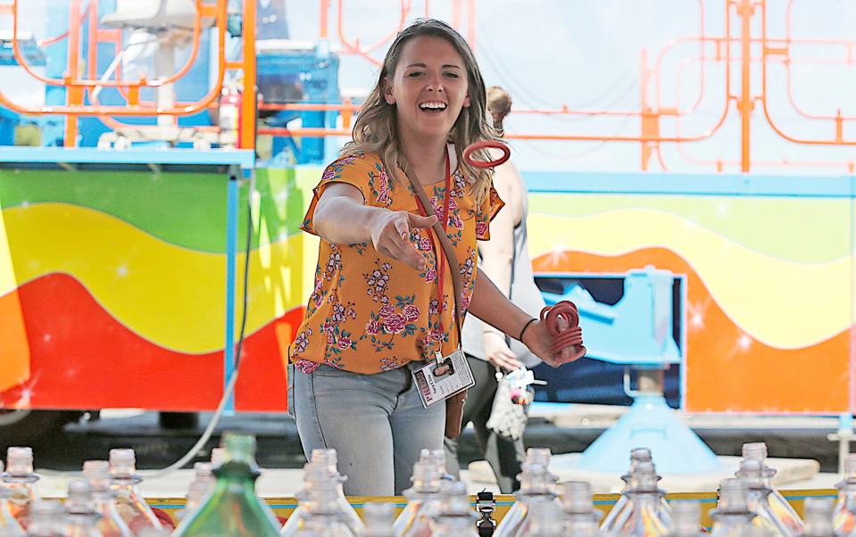 Enterprise reporter Sara Cline tries her luck at the Ring a Bottle game at the Brockton Fair on Monday, July 3, 2017.

Dave DeMelia/The Enterprise