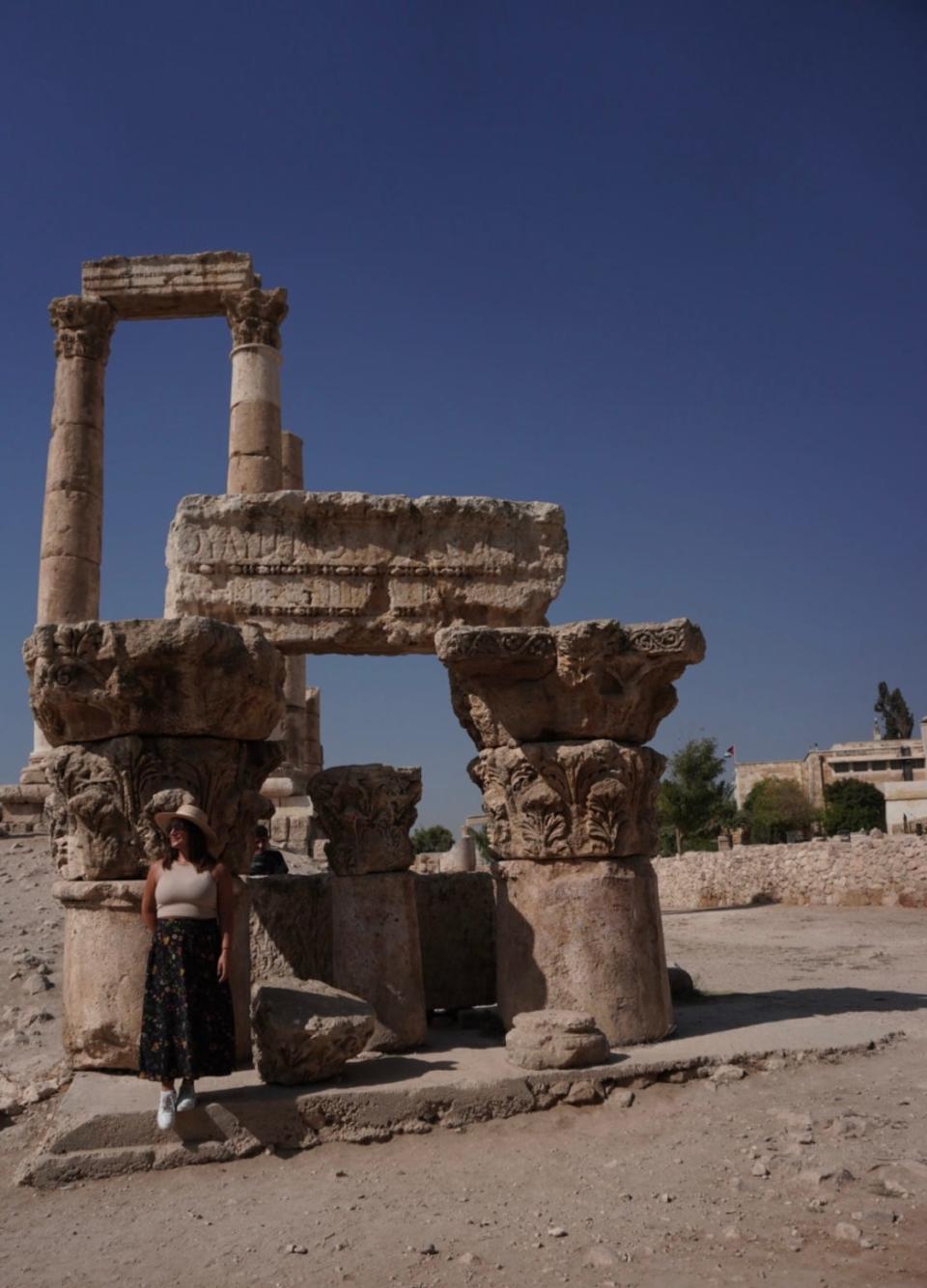 A woman standing in front of ancient remains