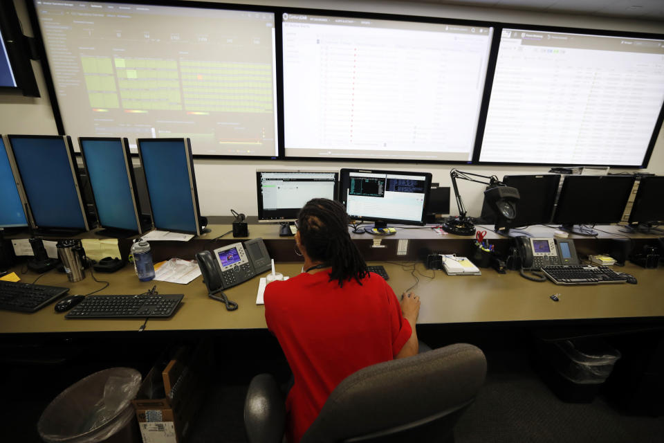 In this Thursday, Sept. 12, 2019, photograph, monitors check their screens in the Governor's Office of Information Technology in downtown Denver. Some cybersecurity professionals are concerned that insurance policies designed to limit the damage of ransomware attacks might actually be encouraging hackers. “We don’t know what that ransom payment is going to fund,” said Brandi Simmons, a spokeswoman for the office. “As a state government, we don’t want to be in a position of funding cyberterrorists.” (AP Photo/David Zalubowski)