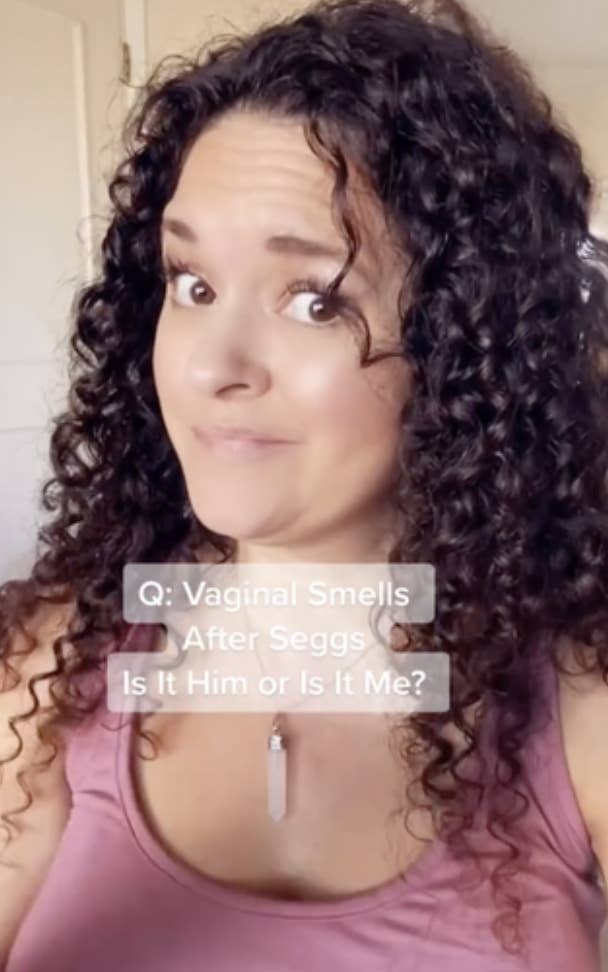 A person with curly hair wearing a tank top is seen with a caption reading, "Q: Vaginal Smells After Seggs Is It Him or Is It Me?"