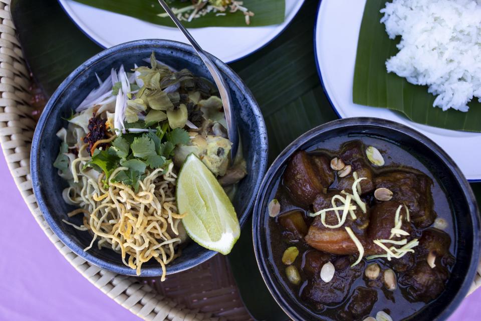 Khao soi gai, a Northern Thai coconut curry with homemade crispy egg noodles (left) and kaeng hang lay, a Burmese/Northern Thai tamarind and ginger curry with pork belly, are pictured on Dec. 15, 2020, in Scottsdale. Alex and Yotaka Martin cook Thai cuisine for their food pop-up, Lom Wong, which is currently available for pickup once a week.