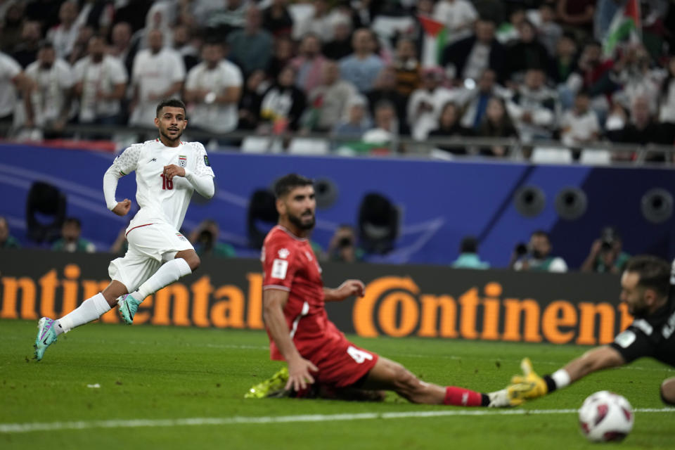 Iran's Mehdi Ghayedi, left, scores his side's third goal during the Asian Cup Group C soccer match between Iran and Palestine at the Education City Stadium in Al Rayyan, Qatar, Sunday, Jan. 14, 2024. (AP Photo/Aijaz Rahi)