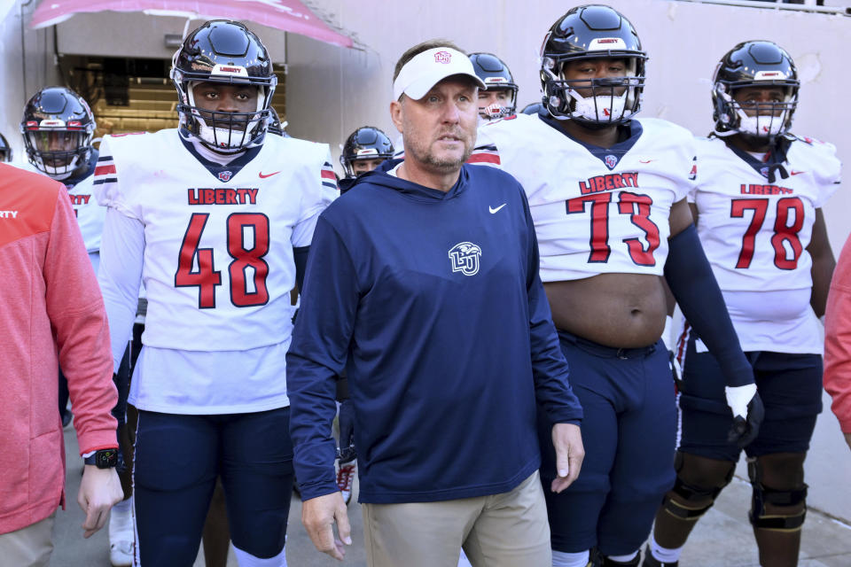 Liberty head coach Hugh Freeze, center, gets ready to take the field with his team to play Arkansas in an NCAA college football game Saturday, Nov. 5, 2022, in Fayetteville, Ark. (AP Photo/Michael Woods)