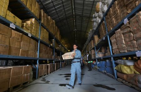 An Afghan policeman carries a medical box at a police medical warehouse in Kabul, August 27, 2014. Picture taken August 27, 2014. REUTERS/Omar Sobhani