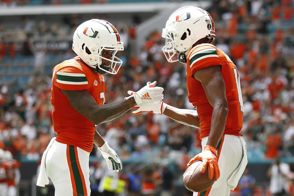 Miami wide receiver Charleston Rambo (11) celebrates with Mike Harley (3) after a touchdown reception during the second quarter of an NCAA college football game against Michigan State, Saturday, Sept. 18, 2021, in Miami Gardens, Fla. (AP Photo/Michael Reaves)