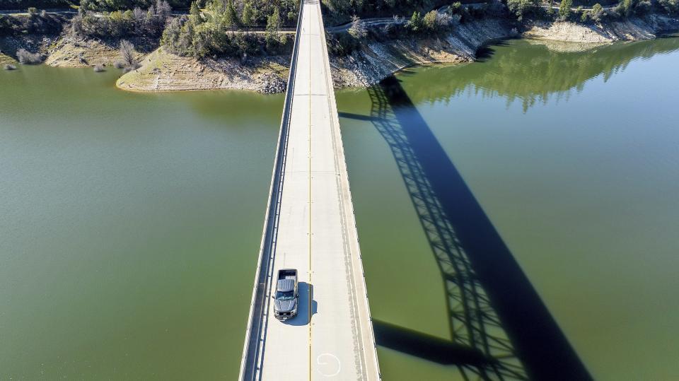 A car crosses Enterprise Bridge over Lake Oroville on Sunday, March 26, 2023, in Butte County, Calif. Months of winter storms have replenished California's key reservoirs after three years of punishing drought. (AP Photo/Noah Berger)